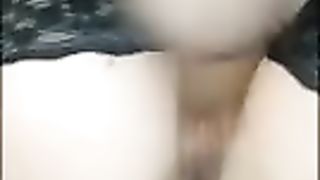 Молодая брюнетка в черных чулках трахает себя бутылкой в киску и жопу